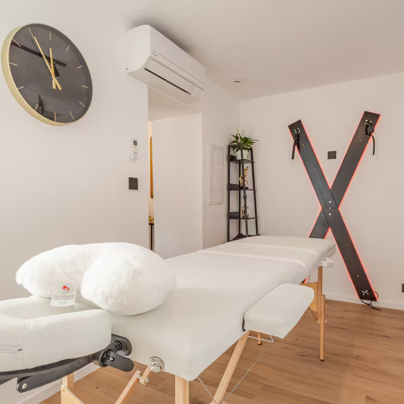 Table de massage et croix de Saint André dans une love room romantique à Flémalle